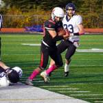 Kenais Bobby Hayes moves with the ball while evading Homers Joe Gordon and Jake Tappan during a Division III playoff game at Justin Maile Field in Soldotna, Alaska, on Saturday, Oct. 7, 2023. (Jake Dye/Peninsula Clarion)