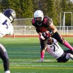 Kenais Bobby Hayes moves with the ball while Homers Nikifor Reutov tries to pull him down during a Division III playoff game at Justin Maile Field in Soldotna, Alaska, on Saturday, Oct. 7, 2023. (Jake Dye/Peninsula Clarion)