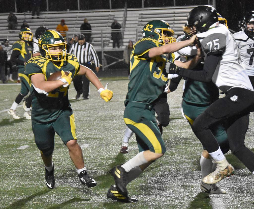 Sewards Kupono Albino runs behind the block of Gideon Schrock on Saturday, Oct. 7, 2023, in the nine-man football state final at Colony High School in Palmer, Alaska. (Photo by Jeff Helminiak/Peninsula Clarion)