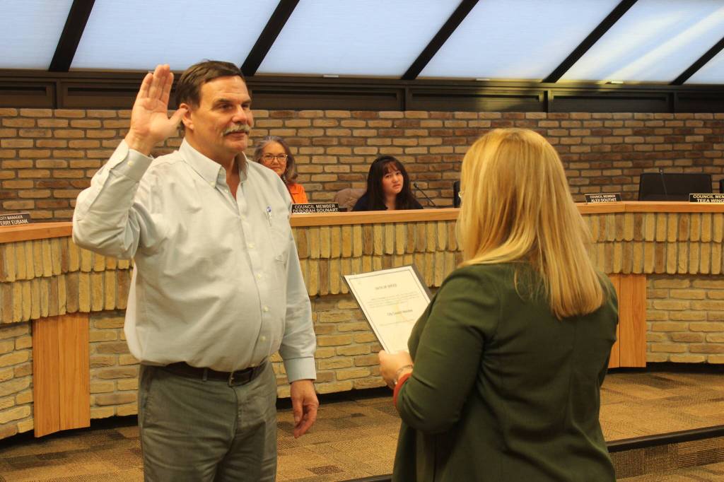 Kenai City Clerk Shellie Saner (right) administers an oath of office to Henry Knackstedt during a Kenai City Council meeting on Thursday, Oct. 19, 2023 in Kenai, Alaska. Knackstedt was elected to the council during the Oct. 3 election. (Ashlyn OHara/Peninsula Clarion)
