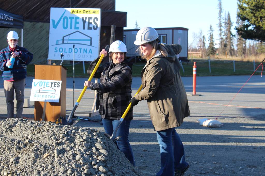 Soldotna City Manager Janette Bower (left) and former Soldotna City Manager Stephanie Queen (right) help break ground on the Soldotna field house project on Friday, Oct. 20, 2023, in Soldotna, Alaska. (Ashlyn OHara/Peninsula Clarion)