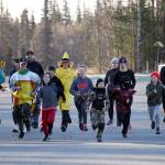 A pack of runners, in costumes and in warm clothes, take off at the start of the Costume Caper at Nikiski Community Recreation Center in Nikiski, Alaska, on Saturday, Oct. 21, 2023. (Jake Dye/Peninsula Clarion)