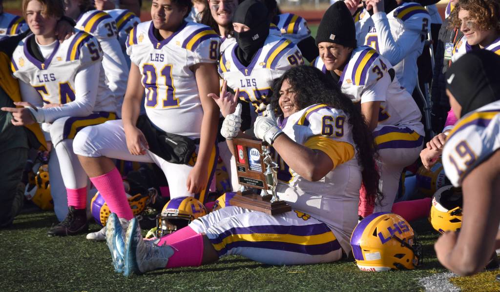 Lathrops Zedekiah Fanene poses with the runner-up trophy Saturday, Oct. 21, 2023, in the Division II championship game at Service High School in Anchorage, Alaska. (Photo by Jeff Helminiak/Peninsula Clarion)