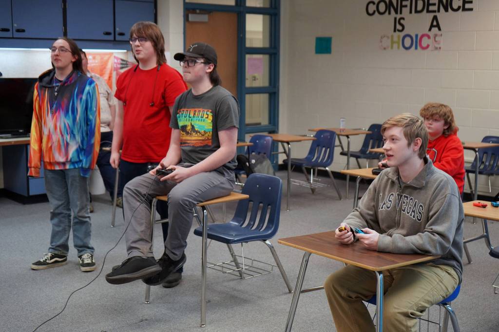Alex Collet and Boyd Lehmberg watch as Kenais Kenneth White and Nikiskis Levi Kimbell compete in Super Smash Bros. Ultimate at Nikiski Middle/High School in Nikiski, Alaska, on Monday, Oct. 23, 2023. (Jake Dye/Peninsula Clarion)