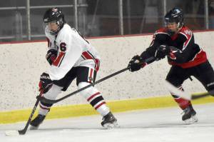 Kenai Central's Braden Smith shields the puck from Houston's Brayden Spain on Thursday, Oct. 26, 2023, at the Kenai Multi-Purpose Facility in Kenai, Alaska. (Photo by Jeff Helminiak/Peninsula Clarion)