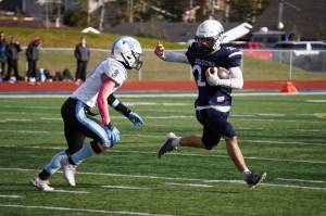 Soldotna's Wyatt Faircloth runs with the ball while fending off Chugiak's Luke Poland during a Division II playoff game at Justin Maile Field in Soldotna, Alaska, on Saturday, Oct. 7, 2023. (Jake Dye/Peninsula Clarion)
