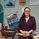 Jessica Dison stands at the counter of Perfectly Alaskan Creations in Kenai, Alaska, on Tuesday, Oct. 31, 2023. (Jake Dye/Peninsula Clarion)