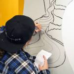 Rachael Montoya works on a section of the mural at the Kenai Art Center in Kenai, Alaska, on Wednesday, Nov. 1, 2023. (Jake Dye/Peninsula Clarion)