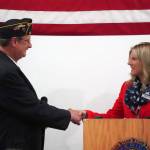 Post 20 Past Cmdr. David Segura shakes the hand of Elaina Spraker, representative for Sen. Dan Sullivan, during a Veterans Day celebration at the American Legion Post 20 in Kenai, Alaska, on Saturday, Nov. 11, 2023. (Jake Dye/Peninsula Clarion)