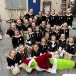 The Hot Chocolate dancers sit for a photo with the Grinch during Forever Christmas 2022. (Photo courtesy Forever Dance)