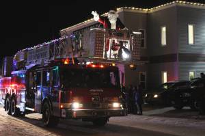 Santa Claus waves from the top of a Kenai Fire Department fire engine during the Christmas Comes to Kenai parade on Friday, Nov. 26, 2021 in Kenai, Alaska. (Ashlyn OHara/Peninsula Clarion)
