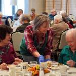 Representatives of Hilcorp distribute Thanksgiving dinners to seniors at the Kenai Senior Center in Kenai, Alaska, on Friday, Nov. 17, 2023. (Jake Dye/Peninsula Clarion)