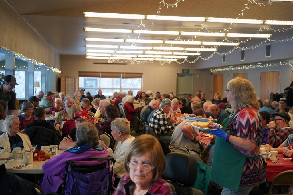 Victoria Askin, right, distributes Thanksgiving dinners to seniors at the Kenai Senior Center in Kenai, Alaska, on Friday, Nov. 17, 2023. (Jake Dye/Peninsula Clarion)