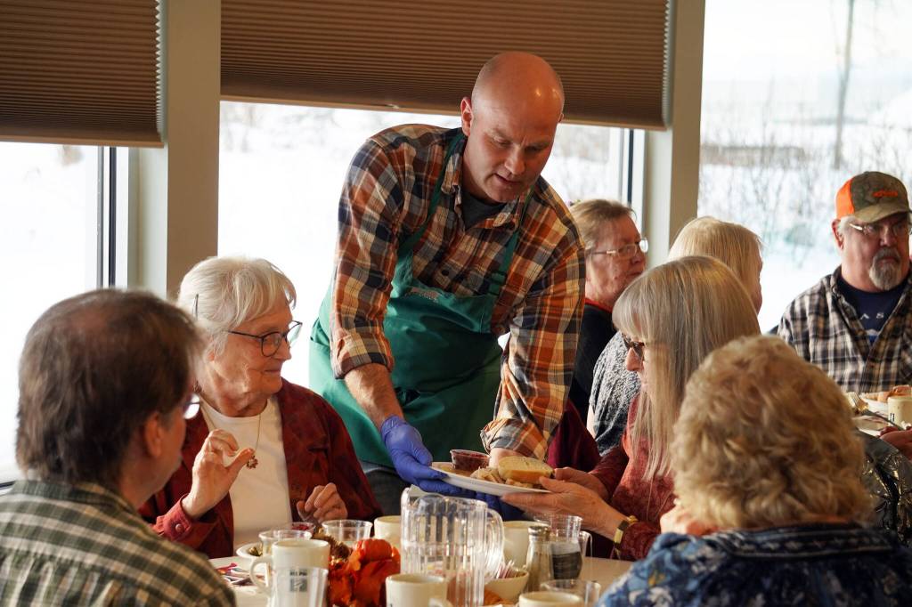 Representatives of Hilcorp distribute Thanksgiving dinners to seniors at the Kenai Senior Center in Kenai, Alaska, on Friday, Nov. 17, 2023. (Jake Dye/Peninsula Clarion)