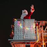 Santa Claus greets children during the Electric Lights Parade, part of Christmas Comes to Kenai festivities, along Frontage Road in Kenai, Alaska, on Friday, Nov. 24, 2023. (Jake Dye/Peninsula Clarion)