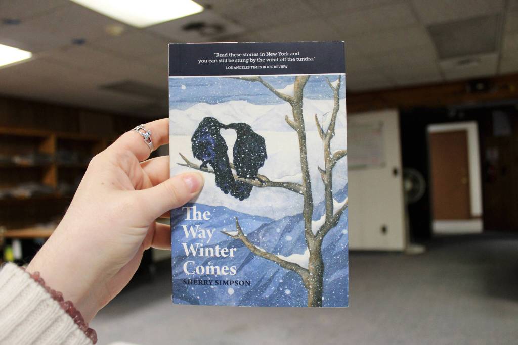 A copy of Sherry Simpsons The Way Winter Comes is held in the Peninsula Clarion offices on Tuesday, Nov. 28, 2023 in Kenai, Alaska. (Ashlyn OHara/Peninsula Clarion)