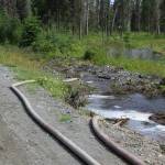 Hoses pump water along Patrick Drive to help mitigate flooding near Kalifornsky Beach Road on Friday, July 21, 2023, near Kenai, Alaska. (Ashlyn OHara/Peninsula Clarion)