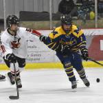 Kenai Centrals Jacob Watt and Homers Zane Barth battle for the puck Thursday, Nov. 30, 2023, at the Kenai Multi-Purpose Facility in Kenai, Alaska. (Photo by Jeff Helminiak/Peninsula Clarion)