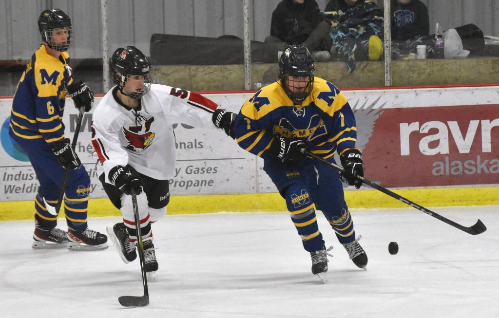 Kenai Centrals Jacob Watt and Homers Zane Barth battle for the puck Thursday, Nov. 30, 2023, at the Kenai Multi-Purpose Facility in Kenai, Alaska. (Photo by Jeff Helminiak/Peninsula Clarion)