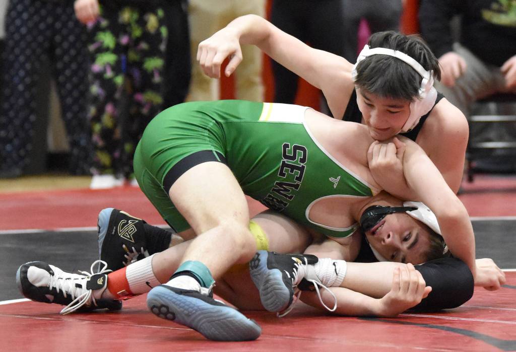 Sewards Aidan Schilling and Kenai Centrals Jaxson Young wrestle in the championship at 119 pounds at the Kachemak Conference wrestling tournament at Kenai Central High School in Kenai, Alaska, on Saturday, Dec. 9, 2023. Schilling took a 7-5 decision. (Photo by Jeff Helminiak/Peninsula Clarion)