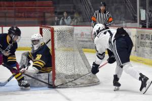 Soldotna's Jace Appelhans stuffs in a goal past Bartlett-East co-op goalie Reece Morton and defender Edwin Maxwell on Friday, Dec. 15, 2023, at the Soldotna Regional Sports Complex in Soldotna, Alaska. (Photo by Jeff Helminiak/Peninsula Clarion)