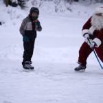 Santa Claus joins children for some hockey action during A Day with the Clauses festivities at Daubenspeck Park in Kenai, Alaska, on Monday, Dec. 18, 2023. (Jake Dye/Peninsula Clarion)