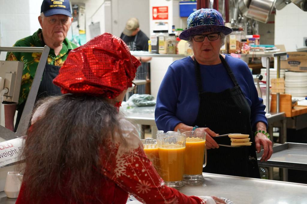 Mrs. Claus takes pancakes from the kitchen during A Day with the Clauses festivities at the Kenai Senior Center in Kenai, Alaska, on Monday, Dec. 18, 2023. (Jake Dye/Peninsula Clarion)