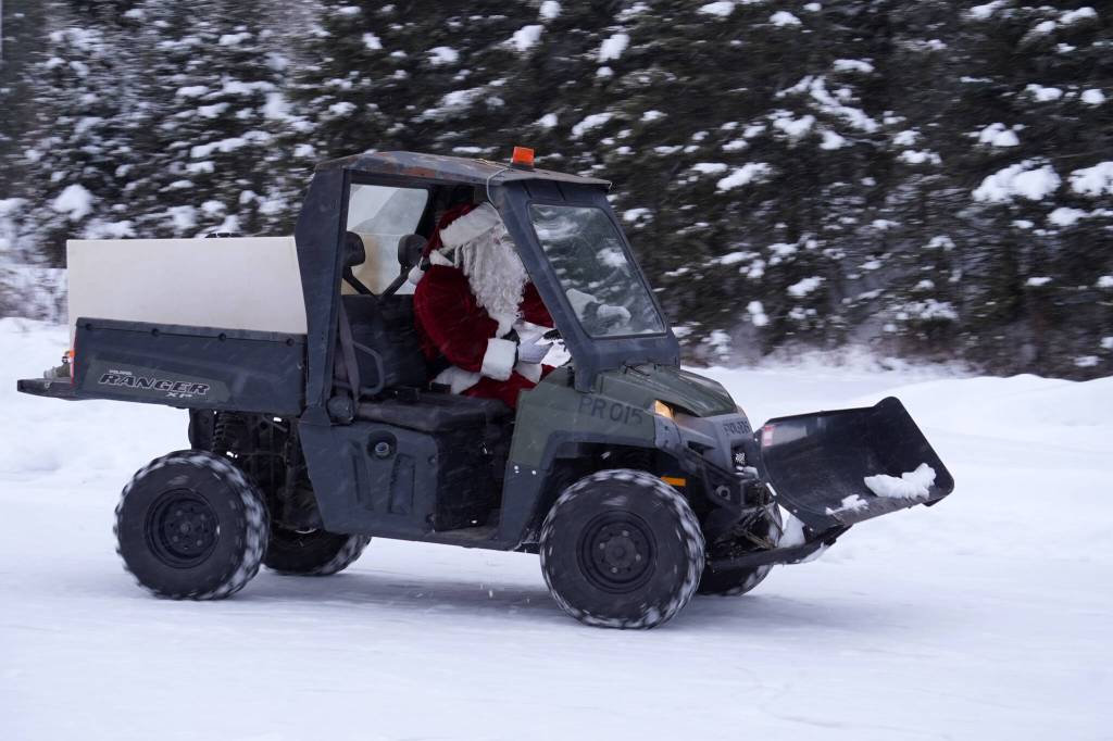 Santa Claus arrives in an ATV during A Day with the Clauses festivities at Daubenspeck Park in Kenai, Alaska, on Monday, Dec. 18, 2023. (Jake Dye/Peninsula Clarion)