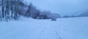 A vehicle is surrounded by avalanche debris along the Seward Highway on Sunday, Dec. 24, 2023 near Cooper Landing, Alaska. (Photo courtesy Alaska Department of Transportation and Public Facilities)
