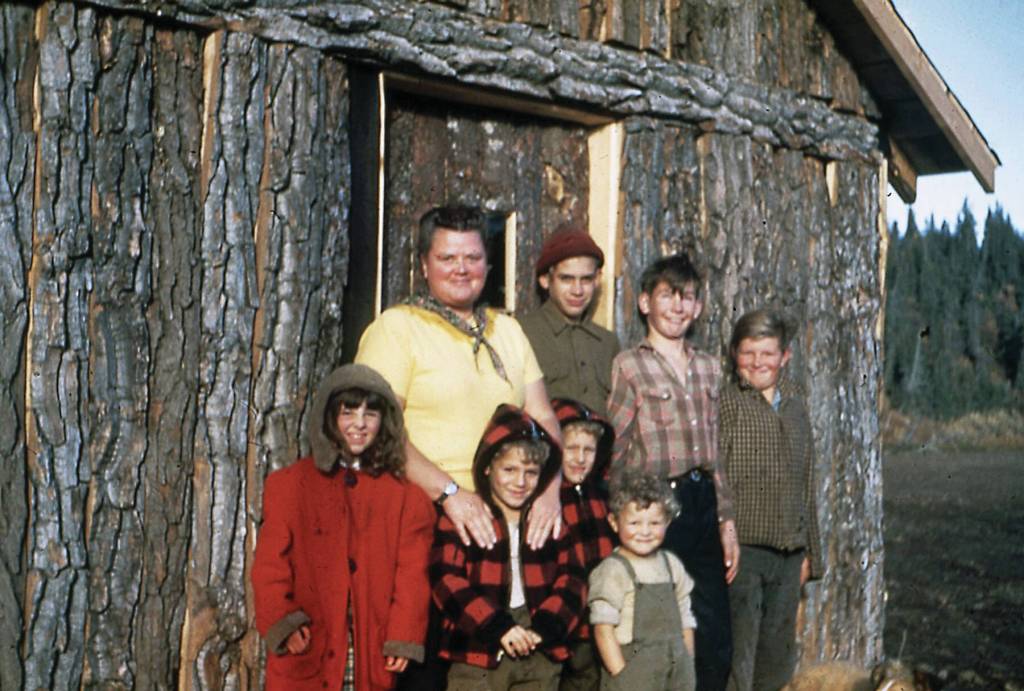 This cottonwood-log structure was Anchor Points first-ever school, located on the south side of the Anchor River. It was replaced with a better school on the north side, on property donated by Sherman and Louvie Chapman. Seen here are the first teacher, Helen Smith, and some of her students, including Larry Keeler standing next to Smith. Louvie Vi Chapman photo courtesy of the Pratt Museum.