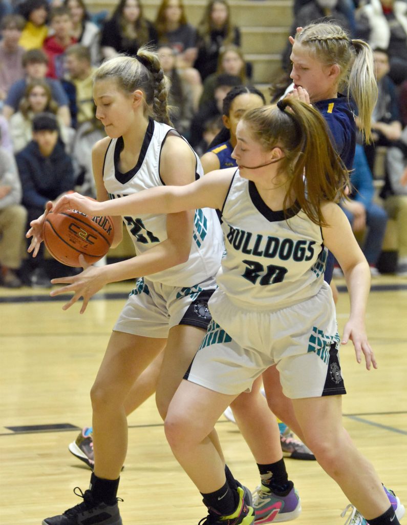 Nikiskis Mandee Roofe and Avery Ellis secure a rebound in front of Homers Sydney Shelby on Friday, Jan. 12, 2024, at Nikiski Middle-High School in Nikiski, Alaska. (Photo by Jeff Helminiak/Peninsula Clarion)