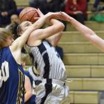 Nikiski's Seth Payne drives against Homer's Justice Davidson and Einar Pederson on Friday, Jan. 12, 2024, at Nikiski Middle-High School in Nikiski, Alaska. (Photo by Jeff Helminiak/Peninsula Clarion)