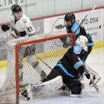 The puck pops in front of Wisconsin Windigo goalie Linards Lipskis as Landon MacDonald of the Kenai River Brown Bears and Erick Comstock of the Windigo look on, on Saturday, Jan. 20, 2024, at the Soldotna Regional Sports Complex in Soldotna, Alaska. (Photo by Jeff Helminiak/Peninsula Clarion)
