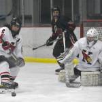Kenai Centrals Logan Mese clears the puck in front of goalie Seanna Swanson on Friday, Jan. 19, 2024, at the Kenai Multi-Purpose Facility in Kenai, Alaska. (Photo by Jeff Helminiak/Peninsula Clarion)