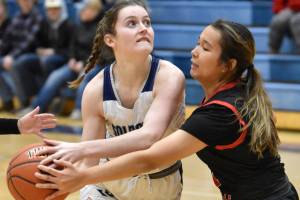 Soldotna's Kaytlin McAnelly drives on Kenai Central's Alex Nelson at the Revolution Sport and Spine Therapy Al Howard Shootout on Thursday, Jan. 25, 2024, at Soldotna High School in Soldotna, Alaska. (Photo by Jeff Helminiak/Peninsula Clarion)