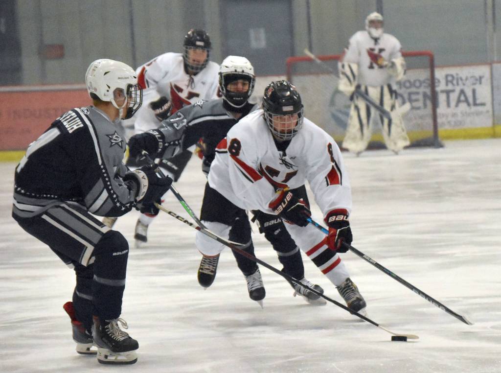 Kenai Centrals Everett Chamberlain brings the puck up against Soldotnas Zack Zurfluh on Friday, Jan. 26, 2024, at the Kenai Multi-Purpose Facility in Kenai, Alaska. (Photo by Jeff Helminiak/Peninsula Clarion)