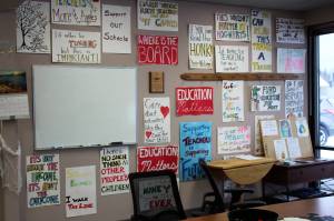 Protest signs hang on the entryway wall at the Kenai Peninsula Education Association office on Thursday, Oct. 28, 2021, in Soldotna, Alaska. (Ashlyn OHara/Peninsula Clarion)