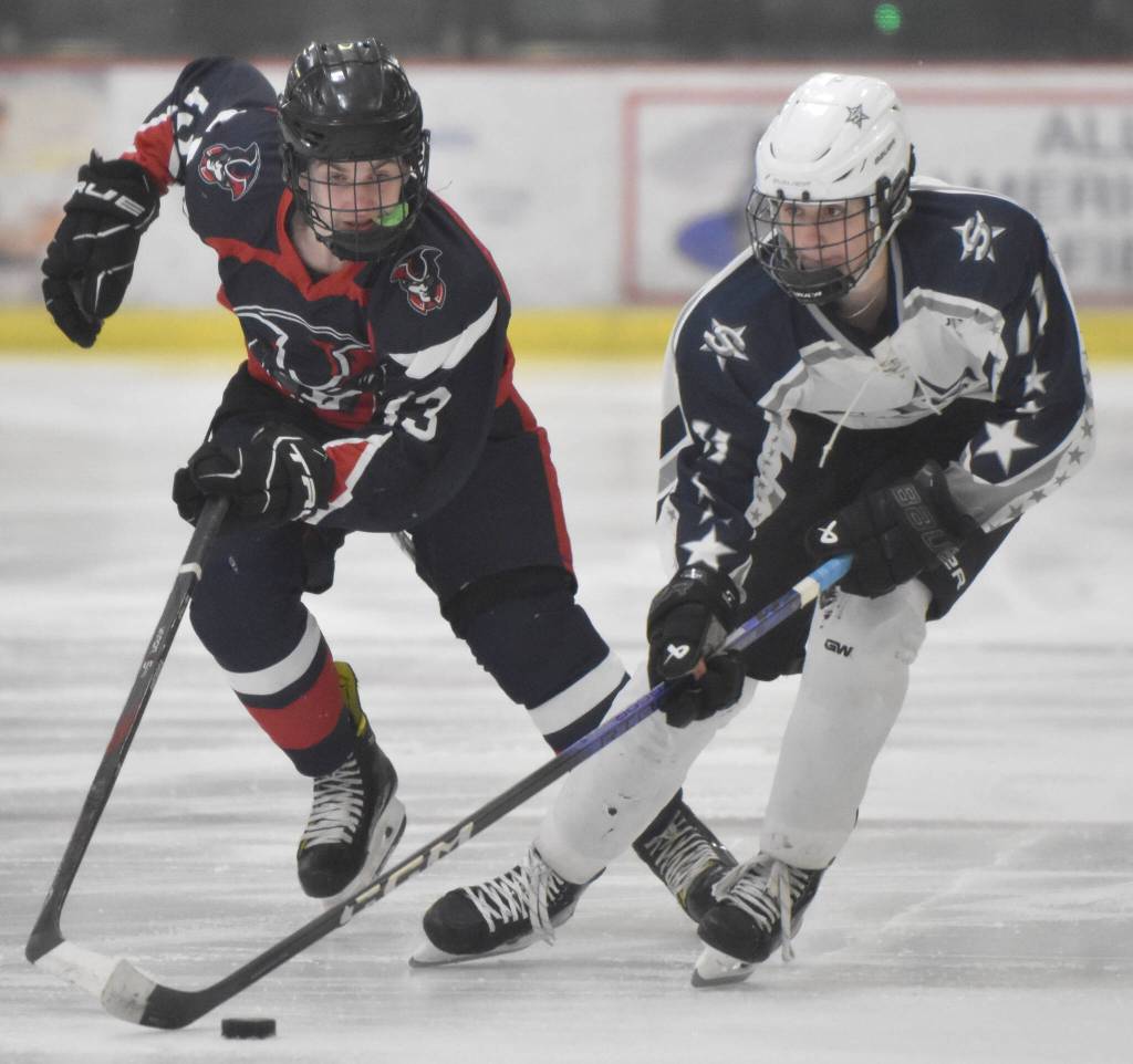 Soldotnas Boone Theiler carries the puck in front of North Poles Max Earl on Thursday, Feb. 1, 2024, at the Division II state hockey tournament at the Soldotna Regional Sports Complex in Soldotna, Alaska. (Photo by Jeff Helminiak/Peninsula Clarion)