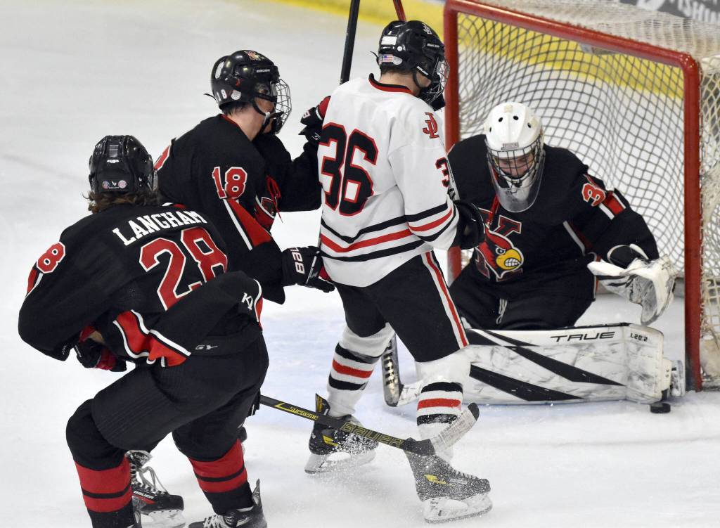 Kenai Central goalie Evyn Witt makes a save in front of Juneau-Douglas:Yadaa.at Kales Elliot Welch on Thursday, Feb. 1, 2024, at the Division II state hockey tournament at the Soldotna Regional Sports Complex in Soldotna, Alaska. (Photo by Jeff Helminiak/Peninsula Clarion)