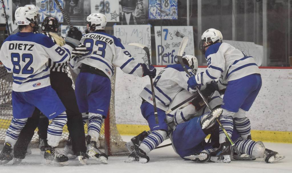 Palmer piles on Elijah Von Gunten after he scored his second of two goals in the final minute to tie the game with Soldotna at 3 at the Division II state tournament Friday, Feb. 2, 2024, at the Soldotna Regional Sports Complex in Soldotna, Alaska. (Photo by Jeff Helminiak/Peninsula Clarion)