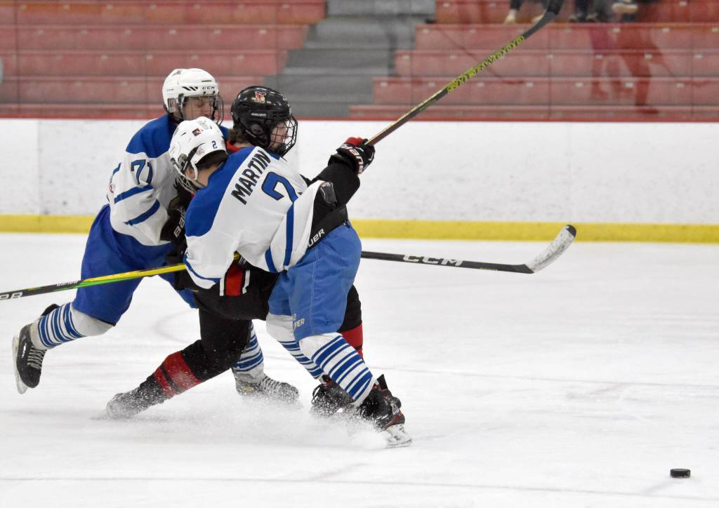 Palmers Nathanael Wright and Ryan Martin keep Kenai Centrals Avery Martin from getting the puck at the Division II state hockey tournament Saturday, Feb. 3, 2024, at the Soldotna Regional Sports Complex in Soldotna, Alaska. (Photo by Jeff Helminiak/Peninsula Clarion)
