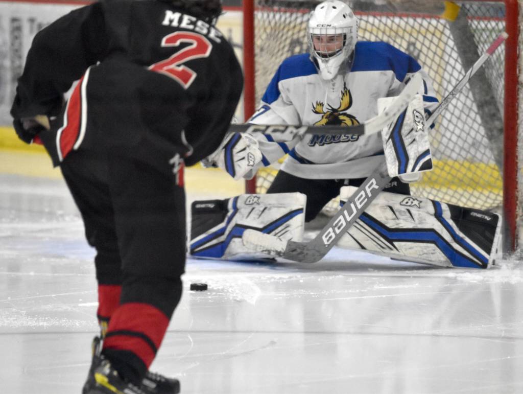 Palmers Keagon OBryan makes a save on Kenai Centrals Logan Mese at the Division II state hockey tournament Saturday, Feb. 3, 2024, at the Soldotna Regional Sports Complex in Soldotna, Alaska. (Photo by Jeff Helminiak/Peninsula Clarion)
