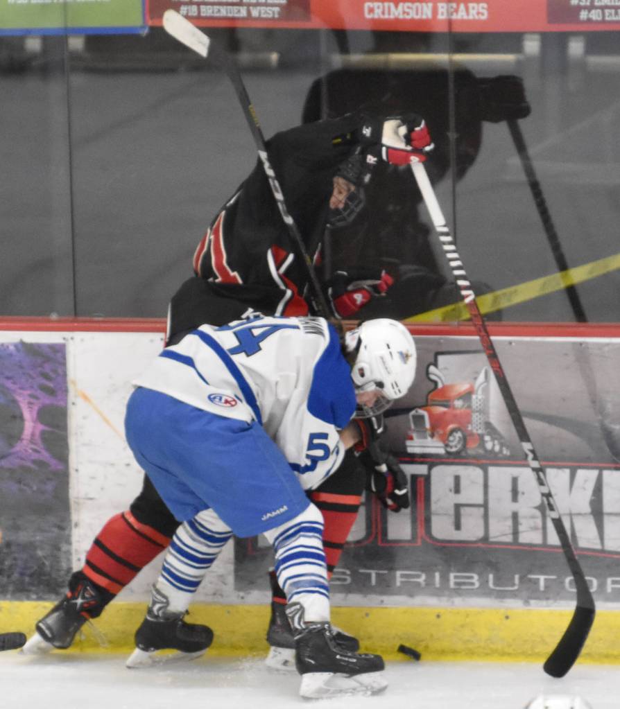 Kenai Centrals Vincent Steen and Palmers Peyton Neumann battle for the puck at the Division II state hockey tournament Saturday, Feb. 3, 2024, at the Soldotna Regional Sports Complex in Soldotna, Alaska. (Photo by Jeff Helminiak/Peninsula Clarion)