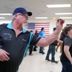 Karl Schmidt readies to loose a dart at the Elks Lodge in Kenai, Alaska, on Saturday, Feb. 3, 2024. (Jake Dye/Peninsula Clarion)