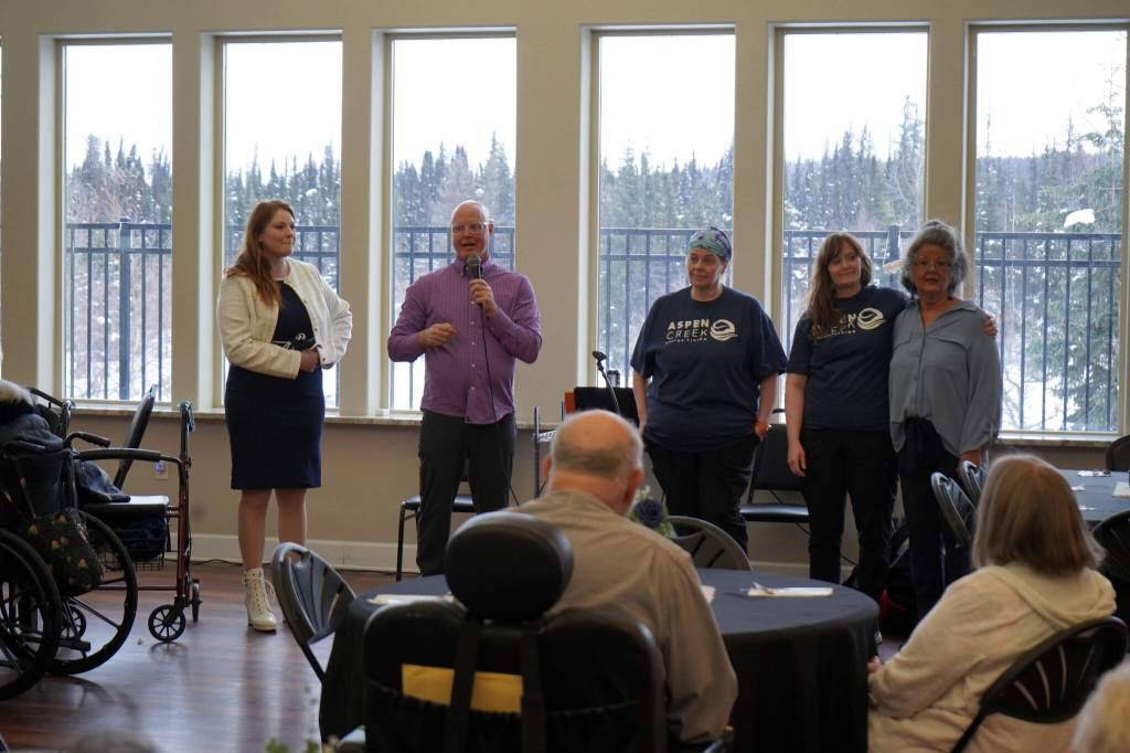 Aspen Creek Senior Living CEO Doug Clegg, with the microphone, calls up members of the Soldotna locations staff during a grand opening event at Aspen Creek Senior Living in Soldotna, Alaska, on Friday, Feb. 9, 2024. (Jake Dye/Peninsula Clarion)