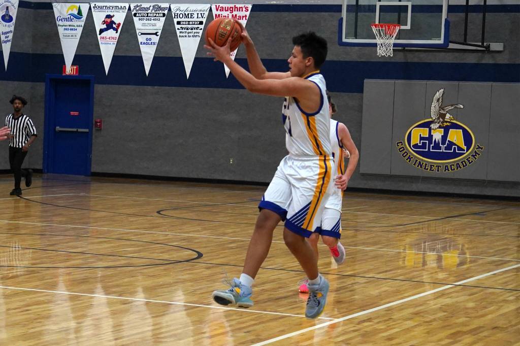Cook Inlet Academys Lucas Oyoumick leaps to catch a pass during a basketball game at Cook Inlet Academy in Soldotna, Alaska, on Tuesday, Feb. 13, 2024. (Jake Dye/Peninsula Clarion)