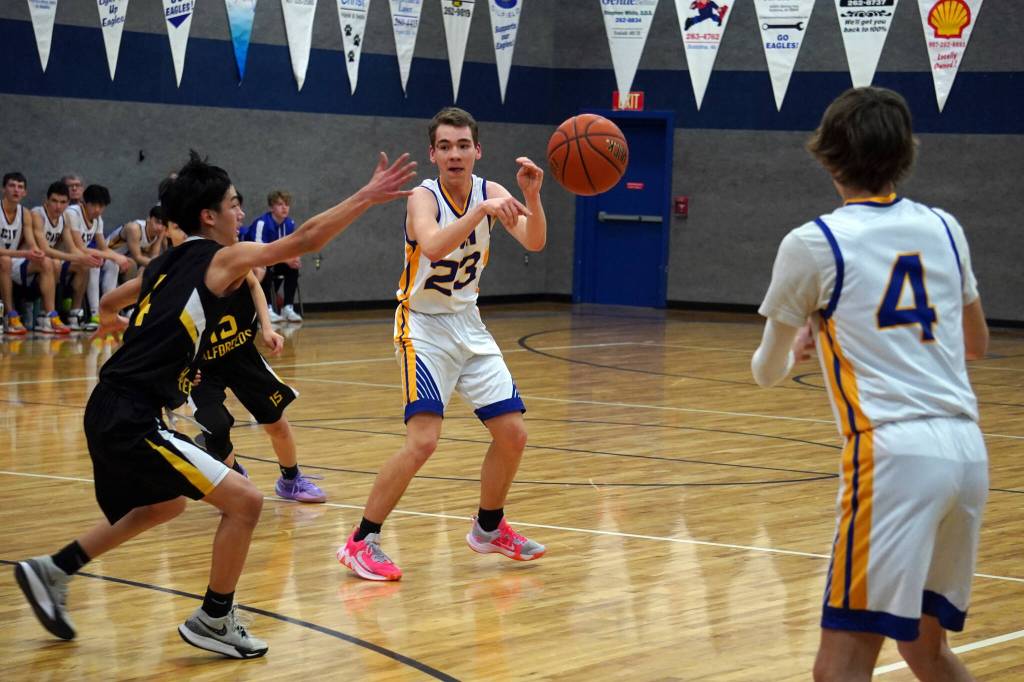 Cook Inlet Academys Owen Braband makes a pass to Trent Waller in front of an attempted block by Aniaks Ralph Steeves during a basketball game at Cook Inlet Academy in Soldotna, Alaska, on Tuesday, Feb. 13, 2024. (Jake Dye/Peninsula Clarion)