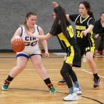Cook Inlet Academys Maria Smith battles to maintain control of the ball against defense by Aniaks Leona Morgan and Maddison Steeves during a basketball game at Cook Inlet Academy in Soldotna, Alaska, on Tuesday, Feb. 13, 2024. (Jake Dye/Peninsula Clarion)