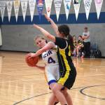 Cook Inlet Academys Mackenzie Carson battles to maintain control of the ball despite blocking by Aniaks Maddison Steeves during a basketball game at Cook Inlet Academy in Soldotna, Alaska, on Tuesday, Feb. 13, 2024. (Jake Dye/Peninsula Clarion)