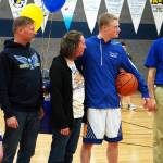 Cook Inlet Academys Jeremy Dillingham stands with his family and coach Ben McGarry as hes honored during senior night festivities at Cook Inlet Academy in Soldotna, Alaska, on Tuesday, Feb. 13, 2024. (Jake Dye/Peninsula Clarion)
